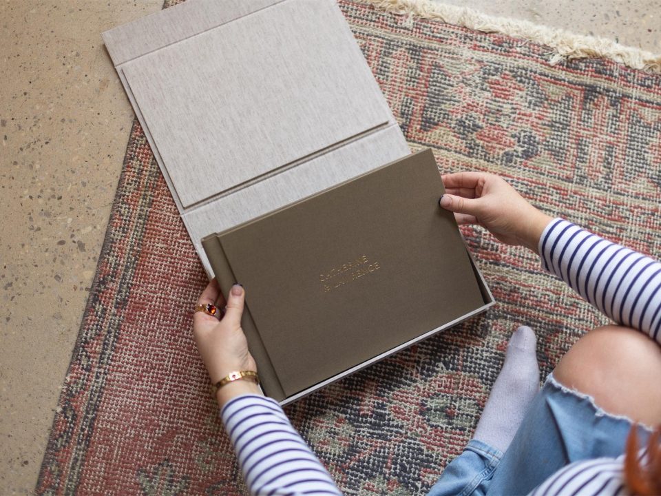 A clamshell box with a landscape matted album being opened and enjoyed