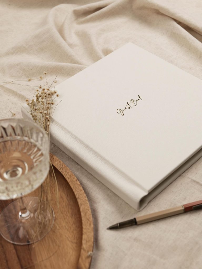 Bespoke bound guest book in leather with gold foiling on a cloth cover table