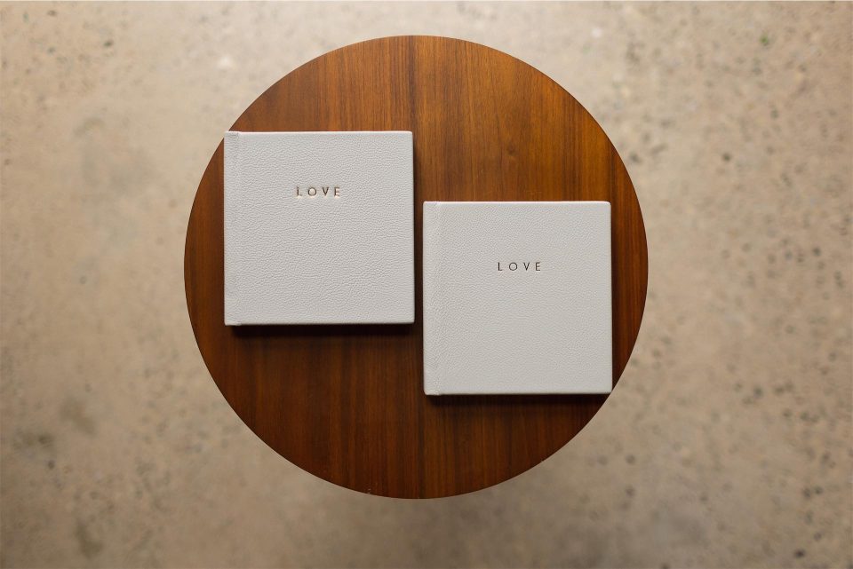 Two mini copy albums with leather covers and gold foiling on a round table