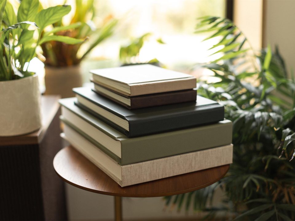 A collection of photo books stacked and with a window behind