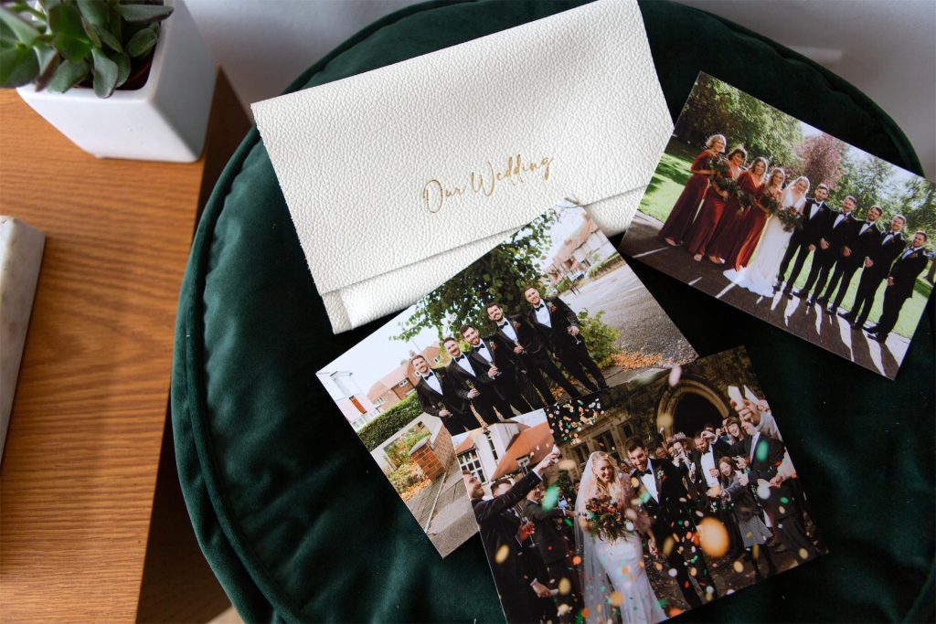 A leather print wallet next to three fine art prints from a wedding