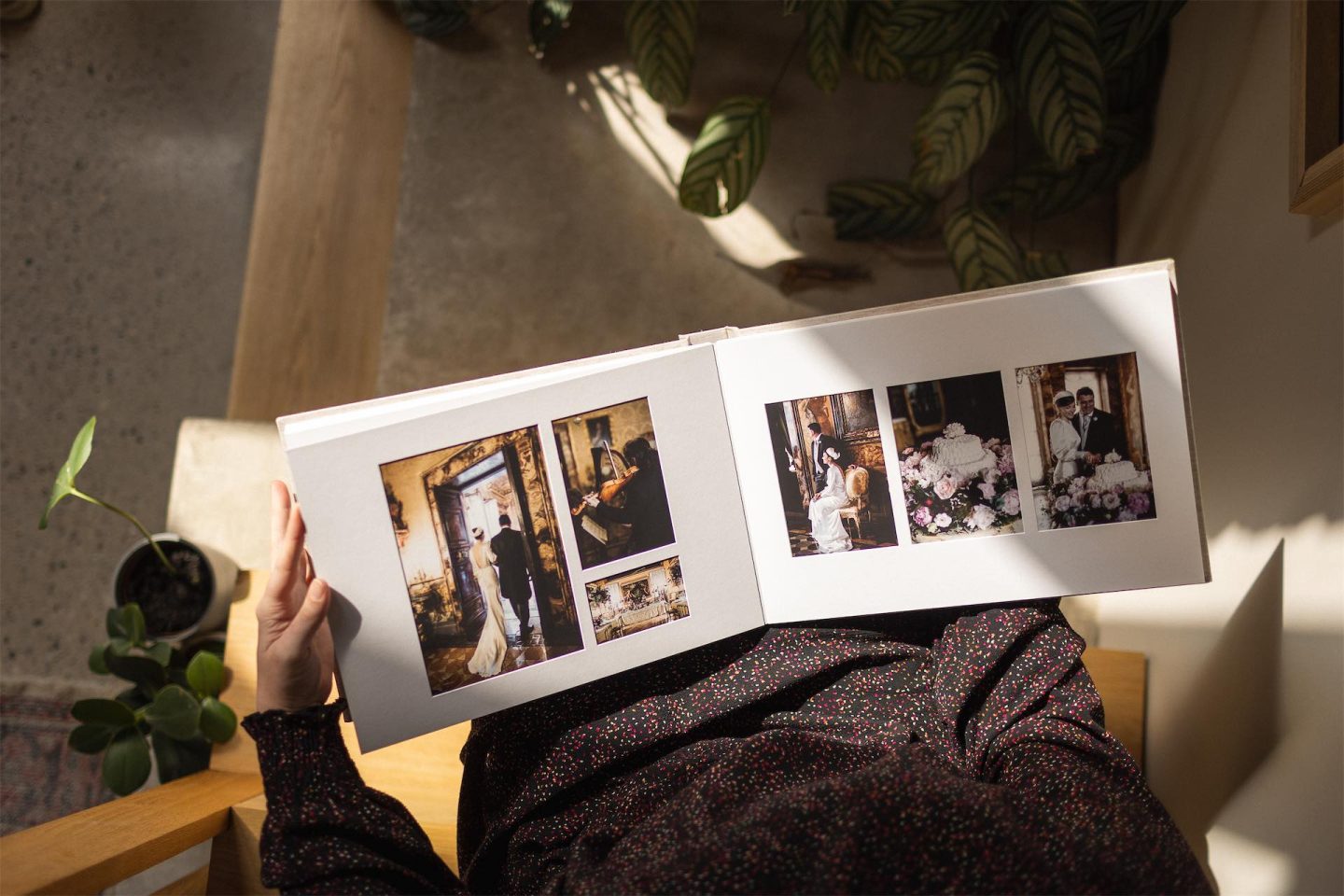 Woman holding wedding matted album with images under overlay mat