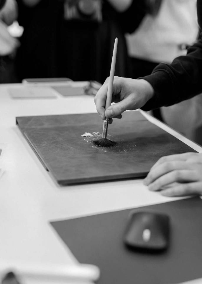 Real gold leaf being applied to a luxury photo book made by the best UK album supplier