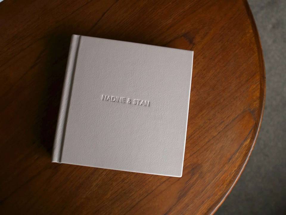 an overhead shot of a photo album on a dark wooden table