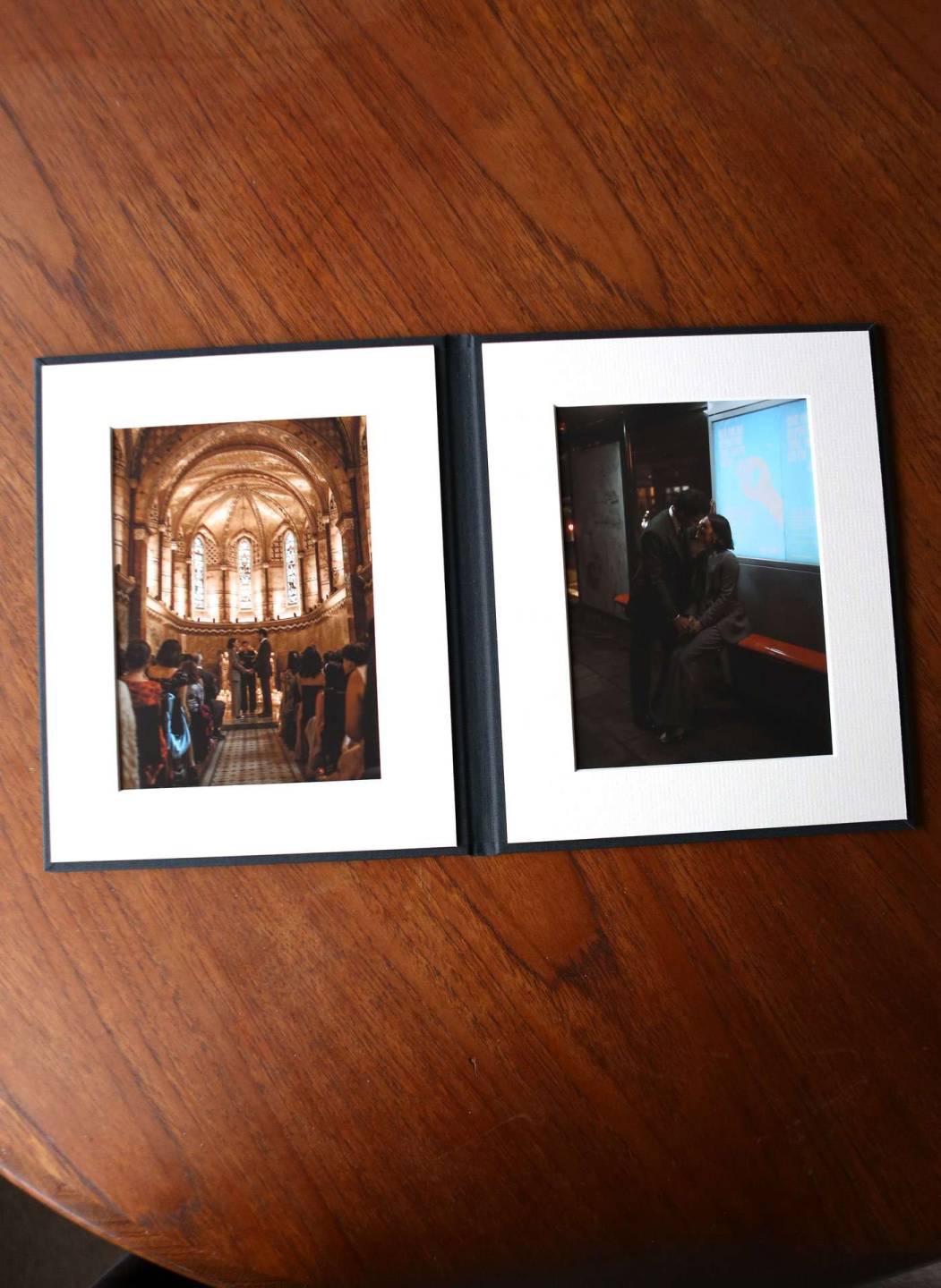 A fine art folio open on a table with wedding photos