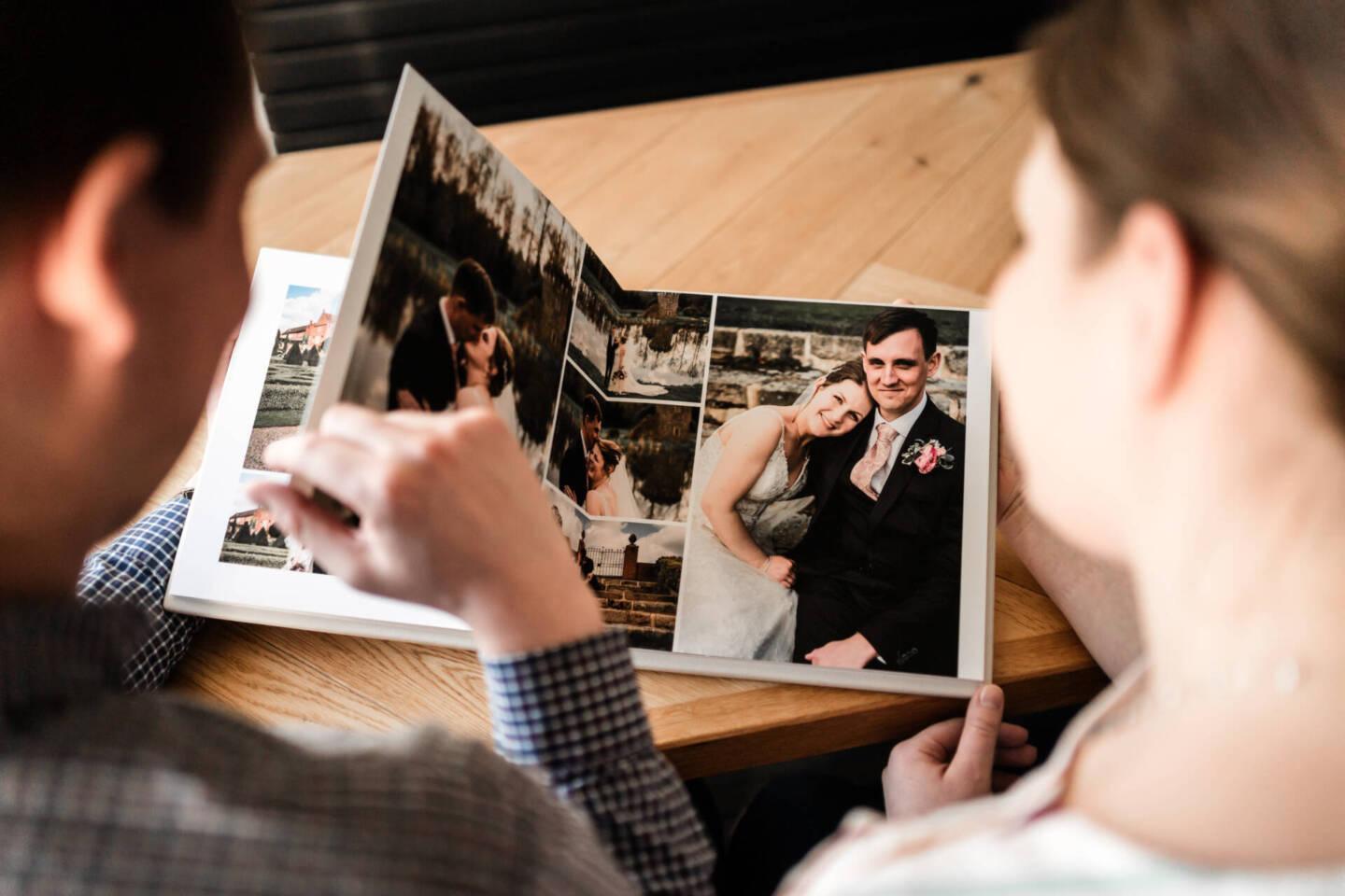 a couple on Valentine's Day looking through their wedding photos in an album on a coffee table