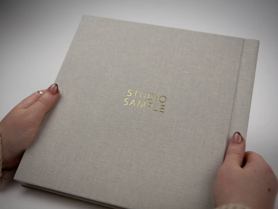 a woman holding a photo album in front of a white background