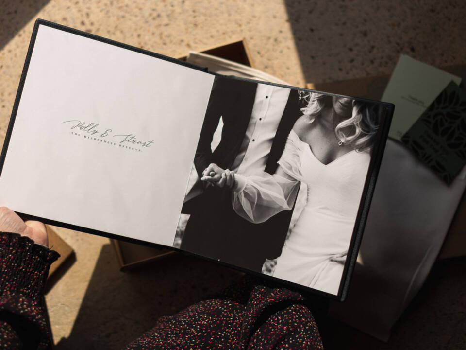 a woman holding a wedding album open with an image on one side and text on the other