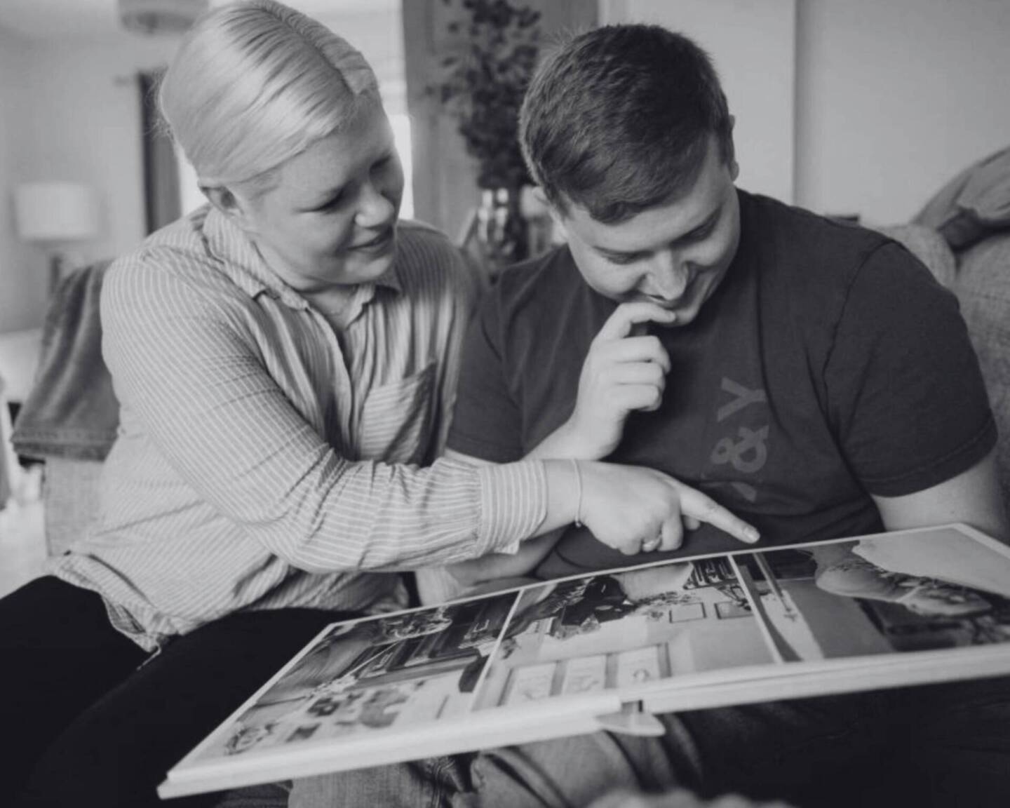 couple looking at wedding album in living room 