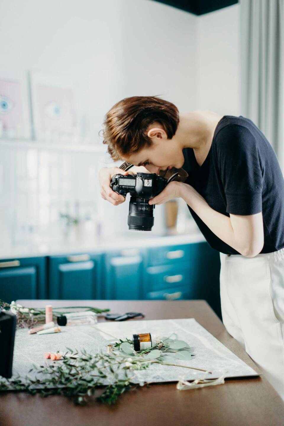 female photographer shooting lay flat photo on a table 