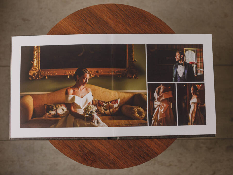 overhead shot of an open print wedding album on a round wooden table