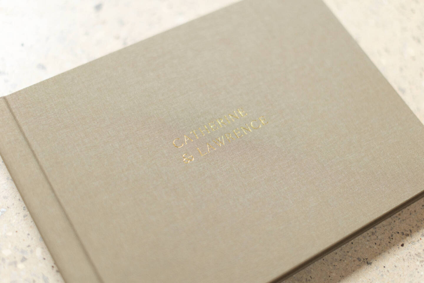 closed up shot of a olive wedding album with gold foiling personalisation 