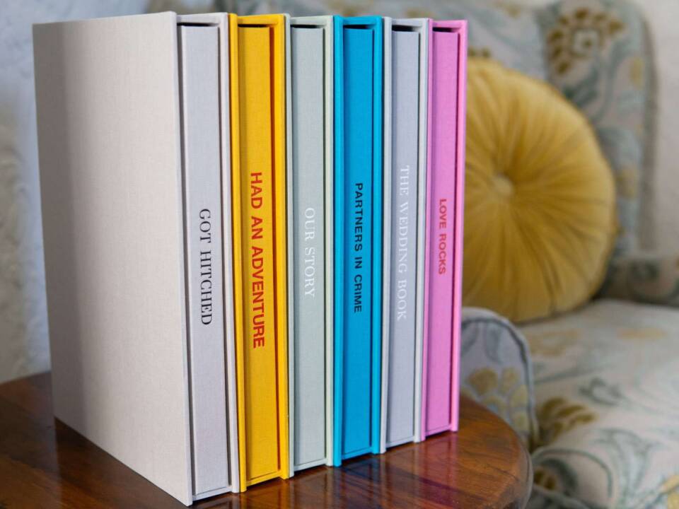A row of high-quality coffee table photo books and slipcases in multiple colours with spine personalisation