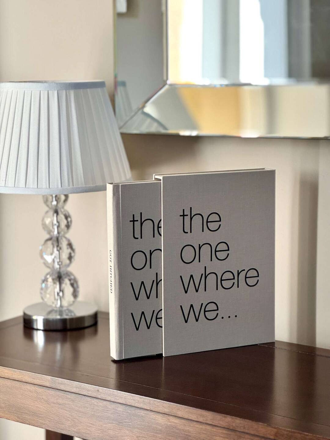 A warm biscuit coloured coffee table photo book with the text The One Where We