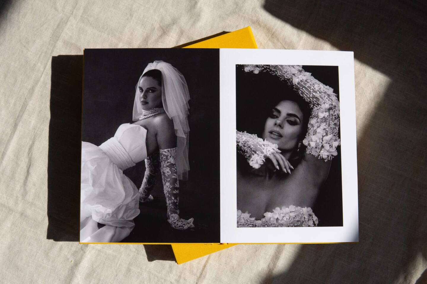 A coffee table book featuring black and white wedding photography of a bride