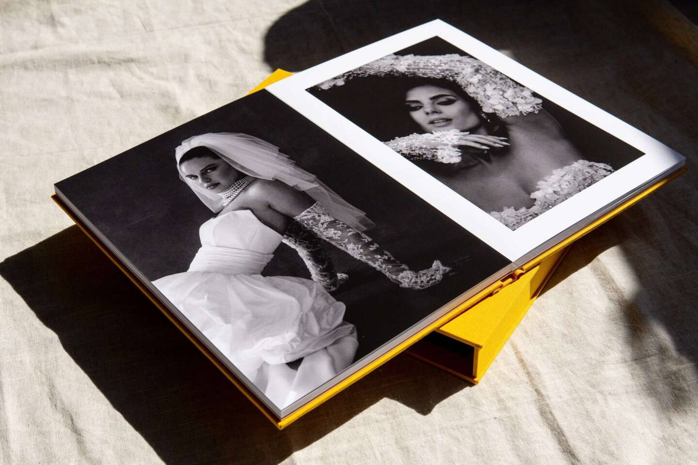 A layflat wedding A4 coffee table book opened to show editorial-style black and white wedding photos