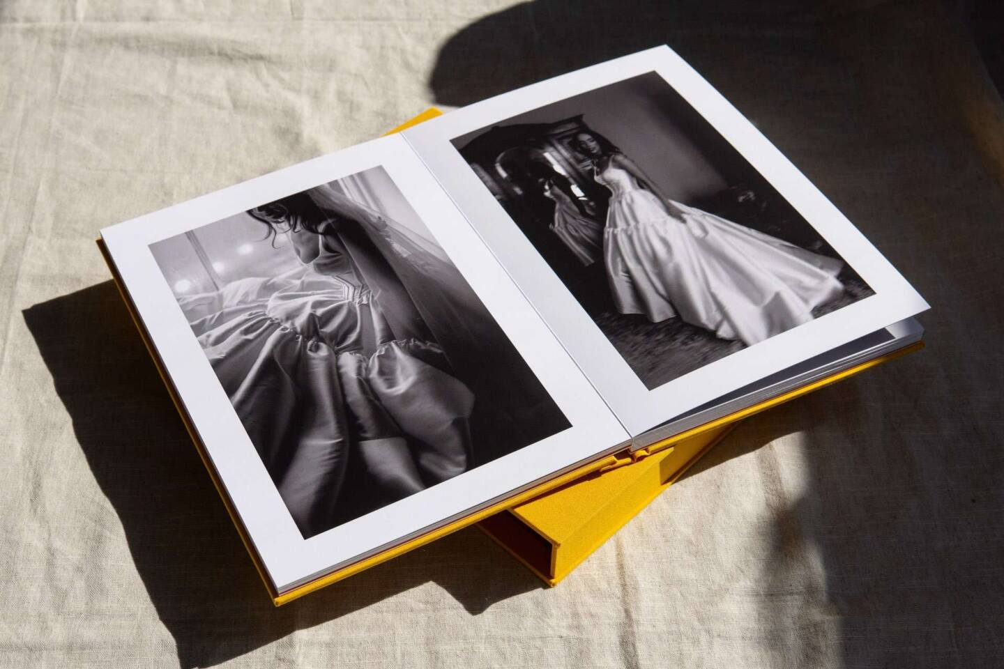A layflat wedding A4 coffee table book open to show editorial-style black and white wedding photos