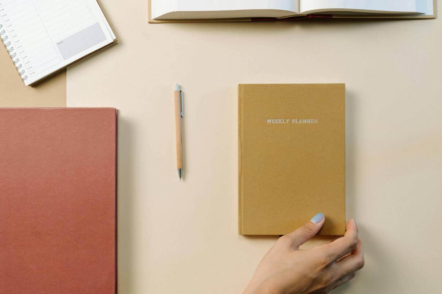 overhead shot of a desk layout with notebooks and pencil
