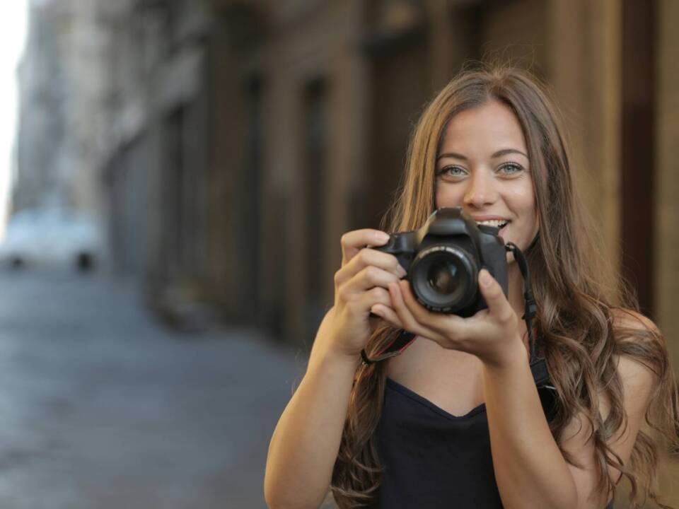 photographer holding a camera smiling with positive mental health